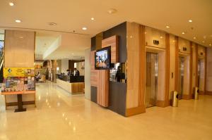 新加坡Hotel Grand Pacific的购物中心的大堂,里面配有电视