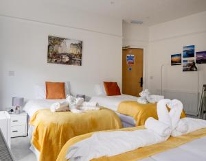 特维德上游的贝里克Homesly Guest Rooms, Comfortable En-suite Guest Rooms with Free Parking and Self Check-in的客房内的两张床和毛巾