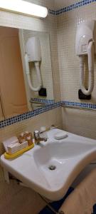 巴勒莫Hotel Trinacria的浴室设有白色水槽和镜子