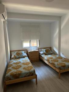 塞维利亚Ameyal Madre Rafols的一间卧室设有两张床和窗户。