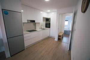 格罗韦Laxiela Apartment的厨房配有白色橱柜和冰箱。