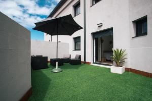 格罗韦Laxiela Apartment的一个带雨伞和绿草的庭院