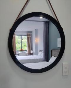 芽庄I Play Inn NT的镜子反射着一间卧室,配有两张床和窗户