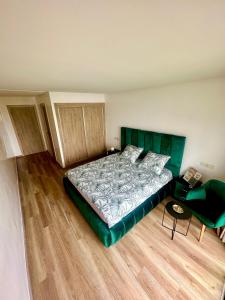 西迪拉哈尔Appartement Cozy avec piscine的一间卧室配有一张大床和绿色床头板