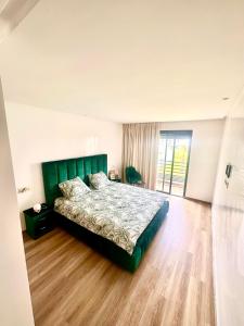 西迪拉哈尔Sidi Rahal的一间卧室设有绿色的床,铺有木地板