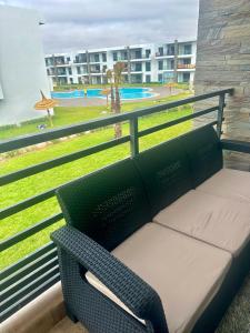 西迪拉哈尔Appartement Cozy avec piscine的享有公园景致的阳台上的长凳