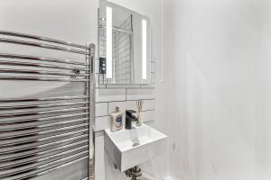 利兹5 Mins From Leeds - 4 Bed - Parking - Sleeps 9的白色的浴室设有水槽和镜子
