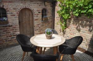 达默Vakantiehuis 't Verloren Schaap Damme的天井上摆放着木桌、椅子和盆栽植物