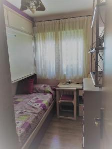 马德里ALQUILER DE HABITACIÓN的一间小卧室,配有一张床和一张书桌