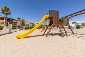 佩尼亚斯科港Sandy Beach Costa Diamante E15 House Game Room Dog Friendly的沙地里有一个黄色滑梯的游乐场
