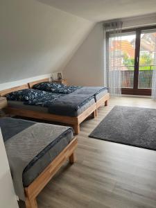 阿尔道夫FMA Ferienwohnung Alfdorf的一间卧室设有三张床和窗户。
