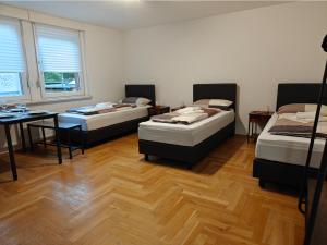 柏林2BR Apartment, Parking, Wi-Fi, TV in Berlin Karow的客房设有三张床、一张桌子和一张书桌