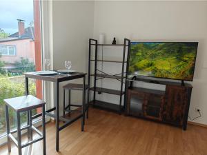 柏林2BR Apartment, Parking, Wi-Fi, TV in Berlin Karow的客厅配有平面电视和2张桌子。