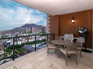 卡波圣卢卡斯Exquisite 3BR Condo Ocean Views Access Resorts的设有一个配有桌椅并享有美景的阳台。