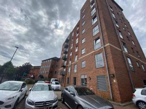 德比Cute 2 bed flat in the heart of Derby By 20Property Stays Short Lets & Serviced Accommodation的停车场内有汽车停放的砖砌建筑