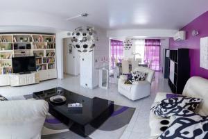 拜马欧La Villa Mussanda avec piscine的客厅设有紫色墙壁和白色家具