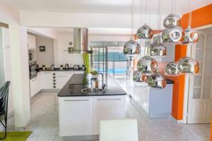 拜马欧La Villa Mussanda avec piscine的厨房配有白色橱柜和水槽