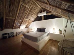 波波约Jungle Shacks : Hoku Casita的一间带一张床的卧室,位于带木制天花板的房间内
