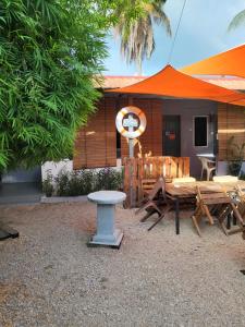 珍南海滩Langkawi Village Budget Rooms的庭院配有桌椅和遮阳伞。