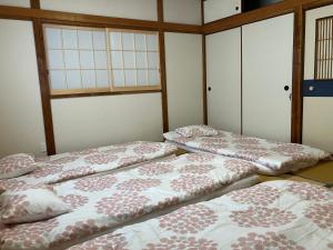 Sanoりんくう館笠松 関西空港的三个床坐在房间里