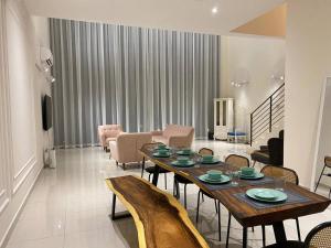 普崇Puchong New Private Pool & Jacuzzi up to 30 Pax的客厅配有木桌和椅子