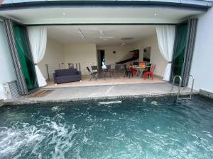 普崇Puchong New Private Pool & Jacuzzi up to 30 Pax的一座带游泳池和客厅的房子