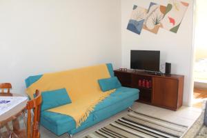 特拉曼达伊Apartamento à Beira-Mar e Centro Tramandaí Frente calçadão的客厅配有蓝色的沙发和电视