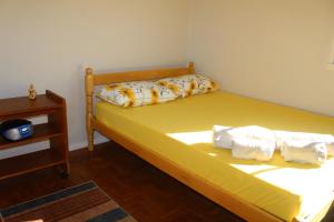 特拉曼达伊Apartamento à Beira-Mar e Centro Tramandaí Frente calçadão的一间卧室配有黄色的床和毛巾
