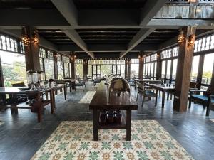 Làng BangAmigo Pu Luong的用餐室设有桌椅和窗户。