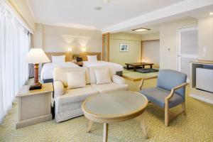 热海瑞斯尔皮亚阿塔米酒店的酒店客房配有床、沙发和电视。