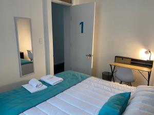圣地亚哥Casona Gorbea Hotel的一间卧室配有一张带镜子和桌子的床