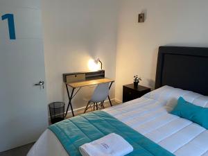 圣地亚哥Casona Gorbea Hotel的一间卧室配有一张床和一张带台灯的书桌