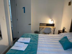 圣地亚哥Casona Gorbea Hotel的一间卧室配有一张床,上面有两条毛巾
