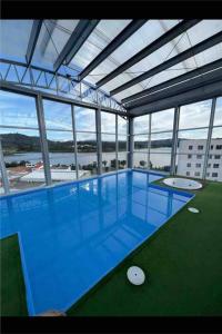 派帕Apartamento con vista al lago.的一座大型建筑,设有大型蓝色游泳池