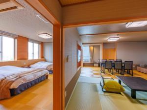 鸟羽户田家酒店的卧室配有一张床和一张桌子及椅子