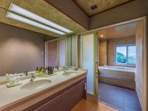鸟羽户田家酒店的一间带两个盥洗盆的浴室和一个大窗户