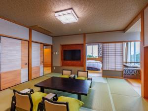 鸟羽户田家酒店的一间带桌椅的房间和一间卧室
