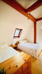 札幌Sapporo Luxury Log House 5Brm max 18ppl 4 free parking的带窗户的客房内的两张床