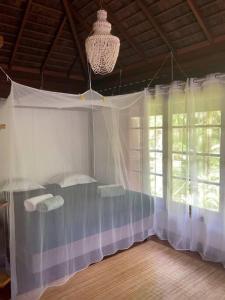 PaopaoVilla JoMana的一间卧室配有带窗帘的床和窗户