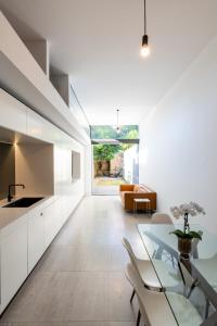 悉尼Paddington House的厨房配有白色橱柜和玻璃桌