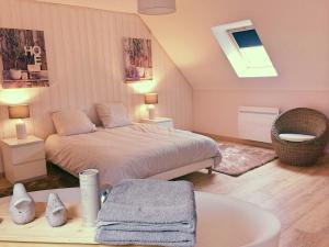 Mons-BoubertLa Ferme d'Antan Baie de Somme的一间卧室配有一张床和一个水槽和一个浴缸