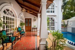 瓦加托Redhomex Villa Esperanza的一个带游泳池和带蓝色椅子的门廊的度假屋