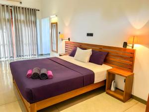韦利格默Tropical Villa - Weligama的一间卧室,配有一张床,上面有两双鞋