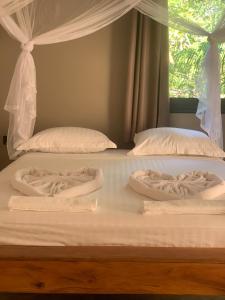 安迪拉纳MAISON CARREE的两张白色的床、白色床单和窗户