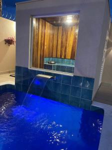 TanabiImpério D的一间带大型蓝色浴缸及窗户的浴室