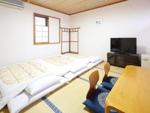 Yōkaichi八日市皇家酒店 的客房设有两张床、一张桌子和一台电视机。