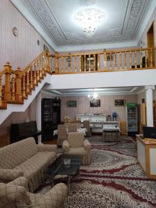 希瓦Sulton-Sayyor的一间带楼梯的客厅和一间带沙发的客厅