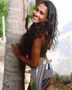 帕西库达Amanda Beach Resort的女人站在树旁边