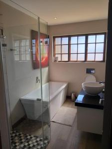 德尔斯特鲁姆Kliphuisjes的带淋浴、浴缸和盥洗盆的浴室