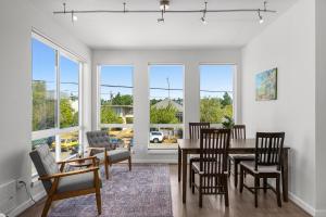 西雅图Modern Luxury Home with EV Garage, Office, Bike & Balcony, WFH & Family Friendly的一间带桌椅和窗户的用餐室